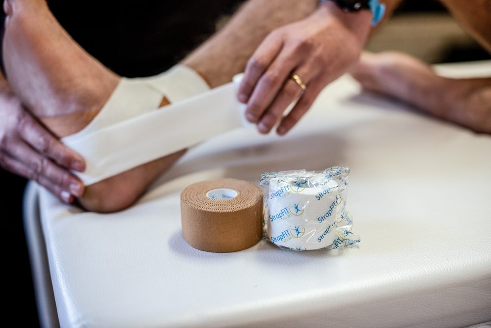 Elastic adhesive bandage being applied to an ankle