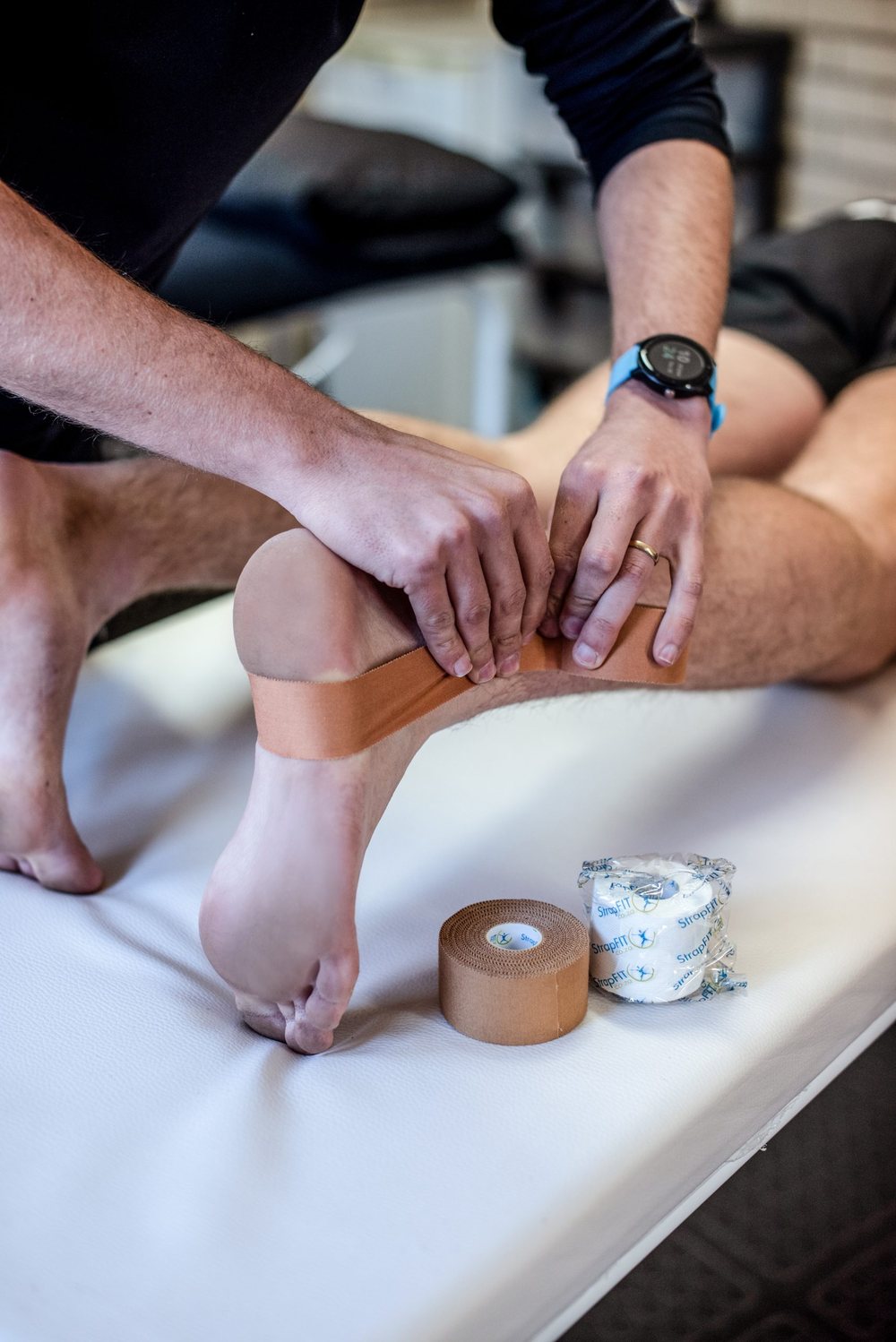 Rigid sports tape being applied to an athlete's knee